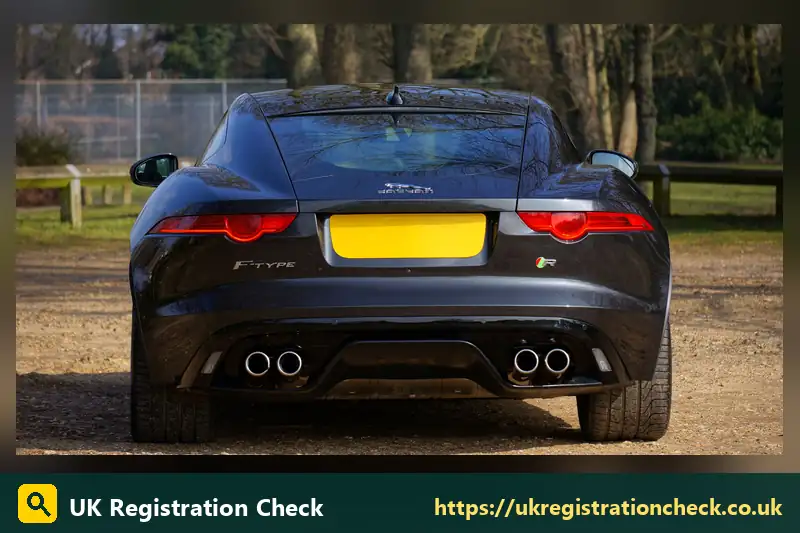 Rear of a dark coupe with a yellow number plate - 74 reg plate