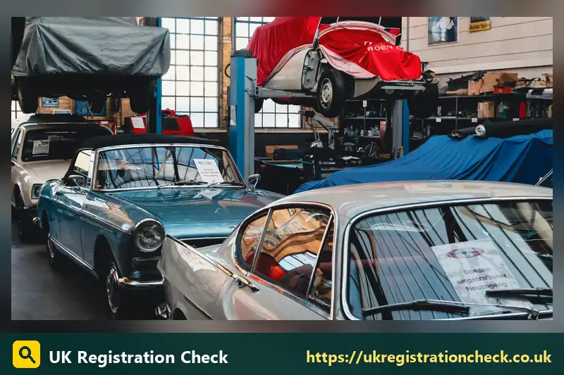 Classic cars parked in a restoration workshop - black license plate uk