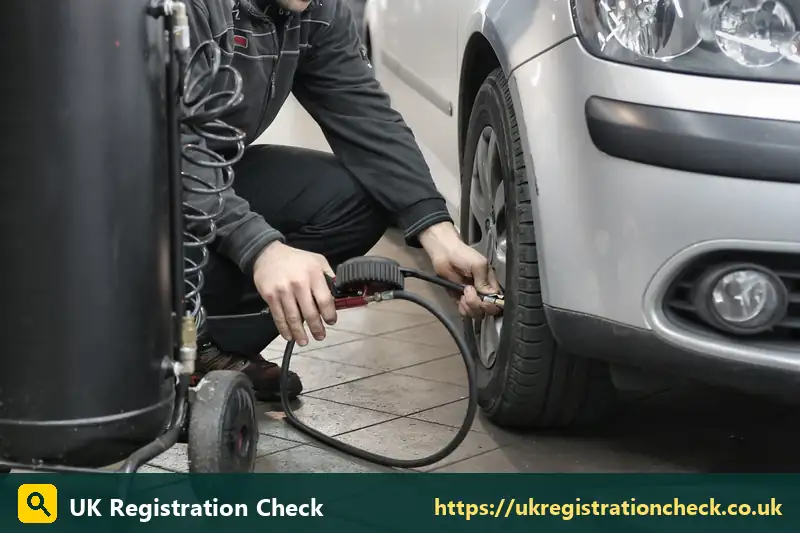Mechanic inflating a car tyre in a garage - car mot history