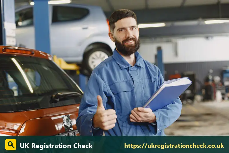 Smiling mechanic holding a folder beside a car - car tax band b
