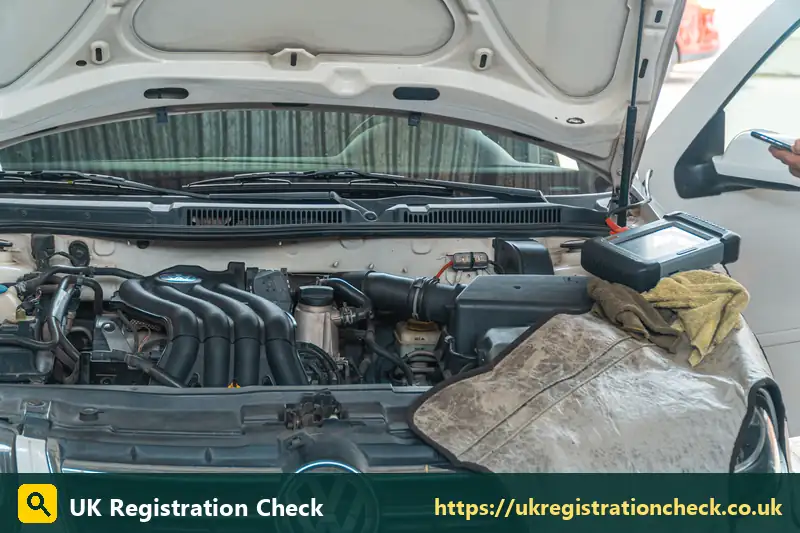 Diagnostic tablet on the engine of a white car - car tax per mile