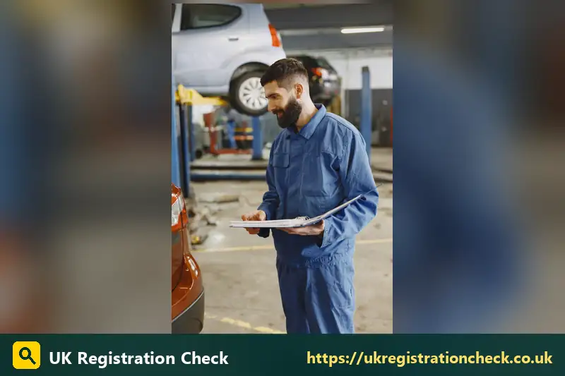 Mechanic holding a clipboard in a garage bay - mot status