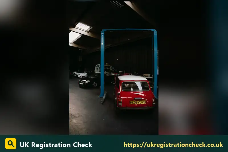 Red classic Mini on a garage lift - number plate years