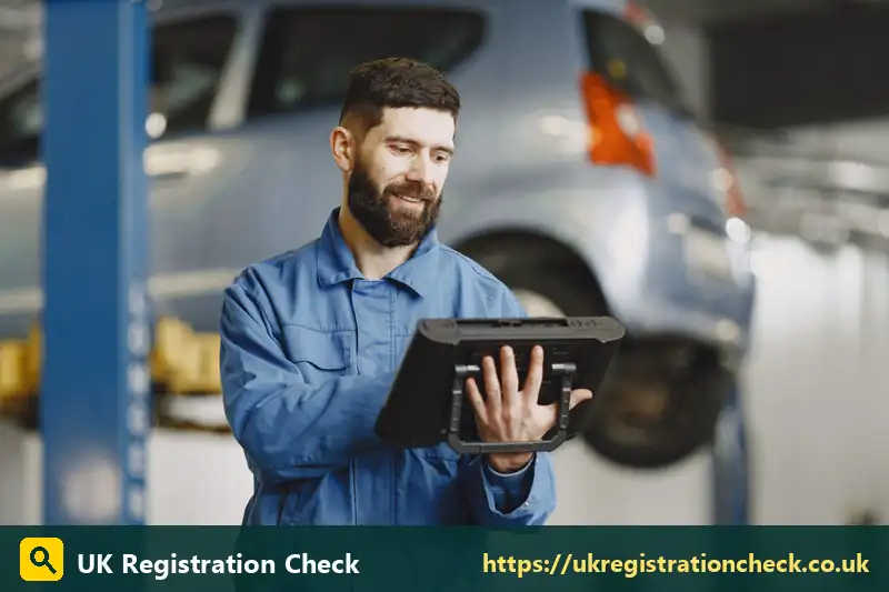 Vehicle inspector holding a tablet in a garage - vehicle excise
