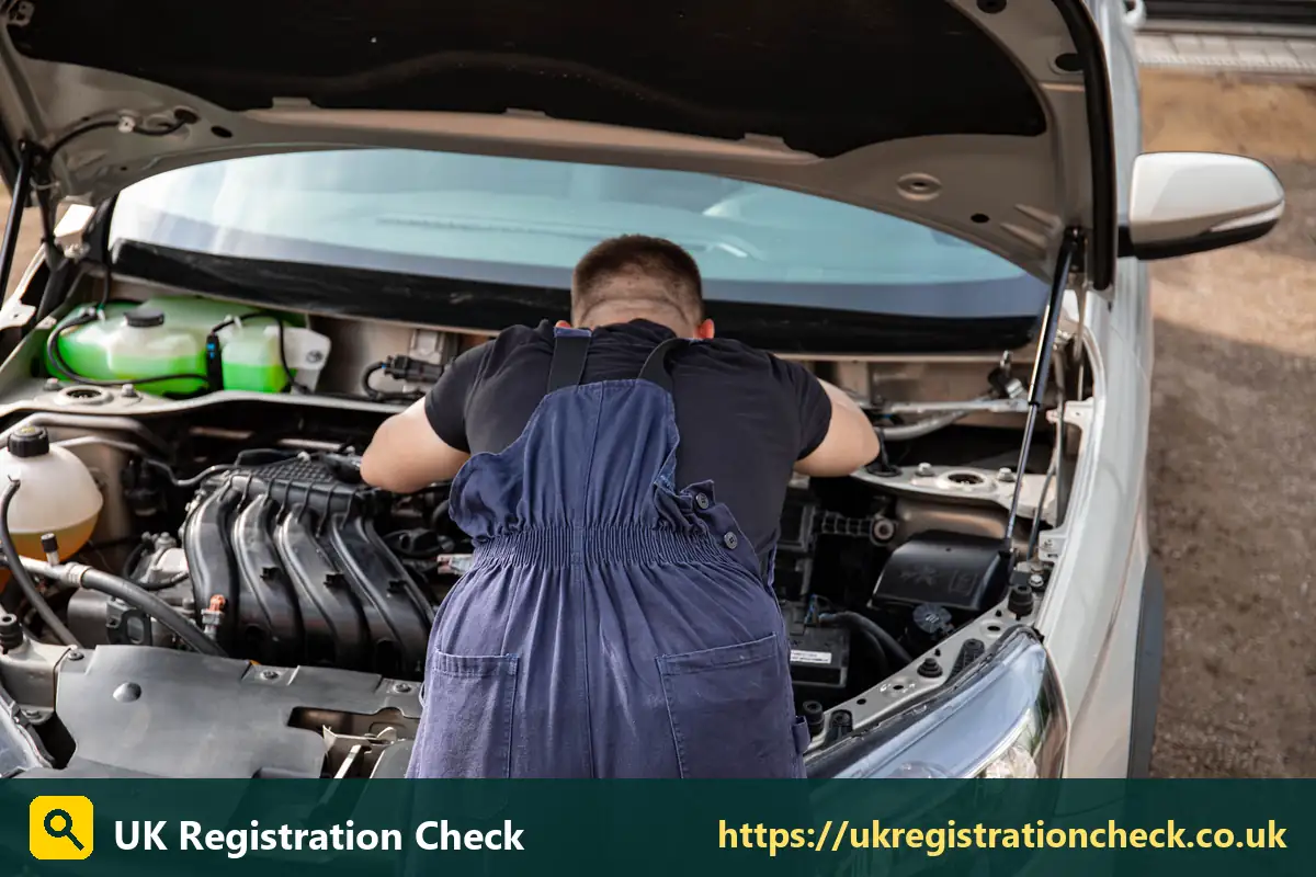 Mechanic bending over a car engine bay - bhp check