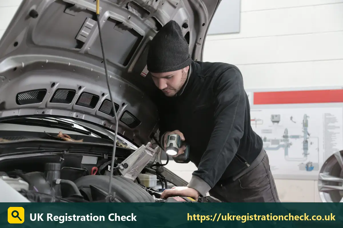 Mechanic inspecting an engine with a torch - co2 emissions checker