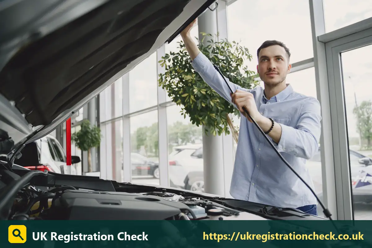 Man checking under the bonnet of a car in a showroom - free vs paid vehicle checks