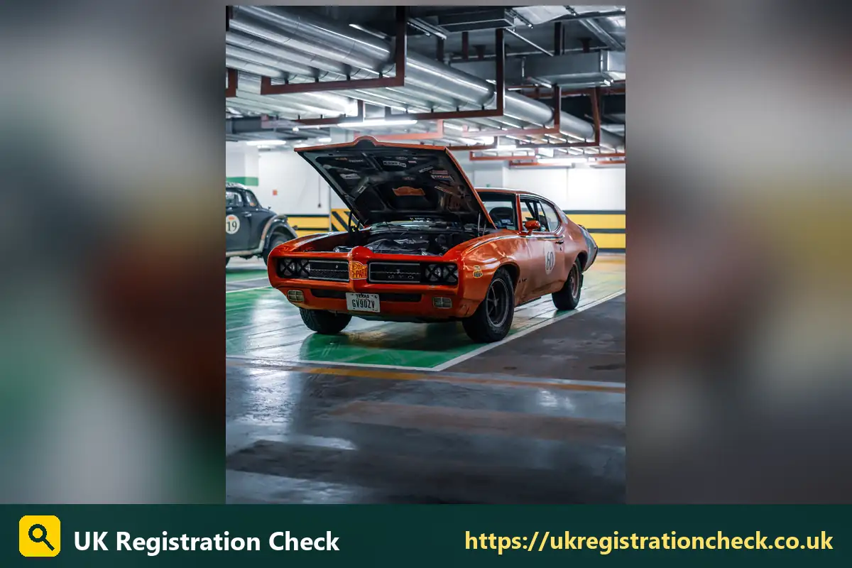 Classic orange muscle car in a garage with the bonnet up - tax for classic cars