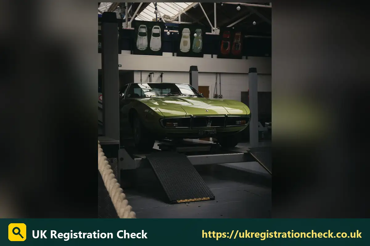 Classic green sports car raised on a garage ramp - vintage vehicle number plates